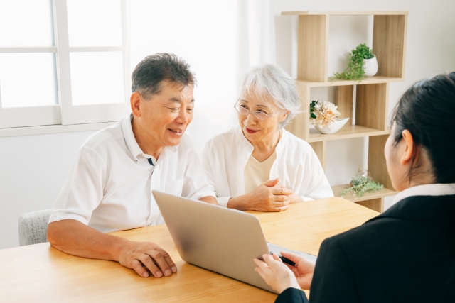 シニア夫婦と説明をしている女性